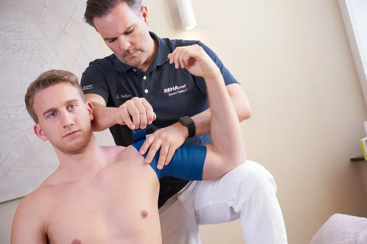 Physiotherapeut Sascha Seifert wendet Flossing am rechten Oberarm eines Patienten an